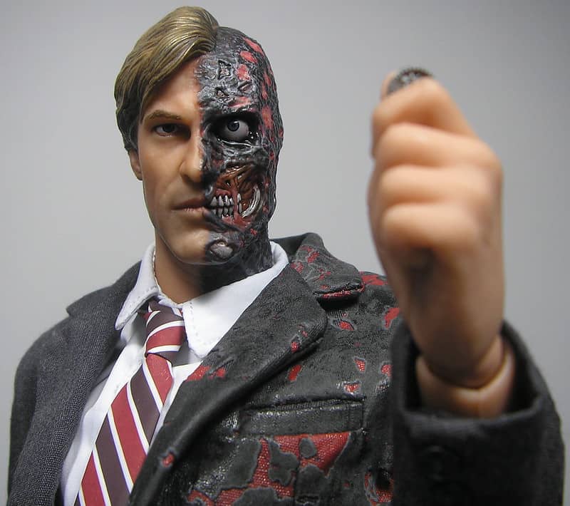 Two Face the comic book character prepares to flip a coin