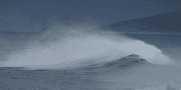 Picture of a crashing wave on the sea surface in a nightly setting