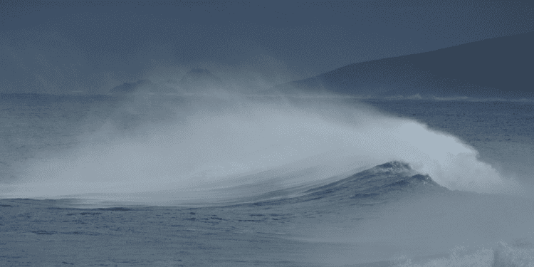 Picture of a crashing wave on the sea surface in a nightly setting